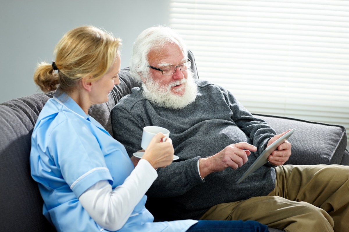 care worker with aged care resident and ipad