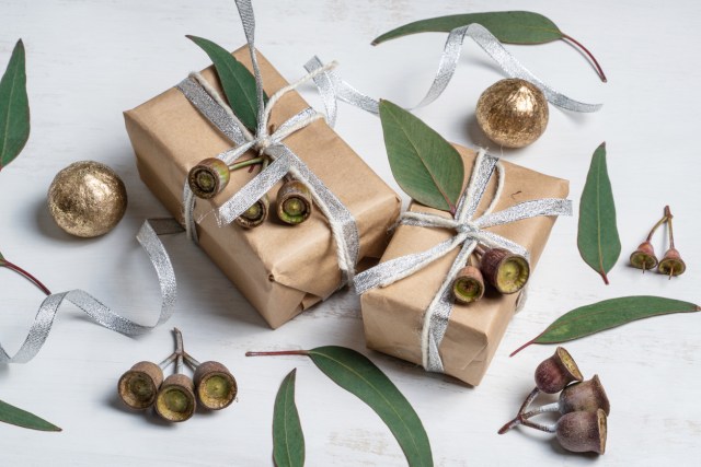Gifts, gum nuts and eucalyptus leaves on a rustic white background.