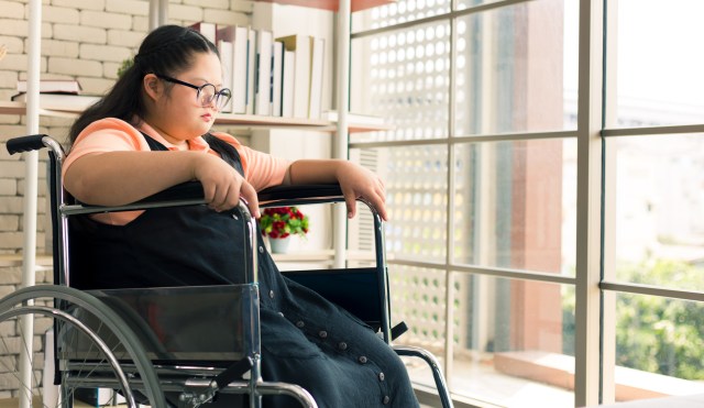 Autism child girl sitting in a wheelchair alone.