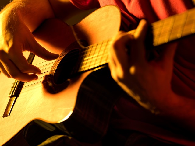 man playing classic guitar on a stage