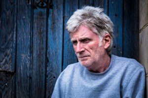 Close up of senior man with beard sitting in doorway