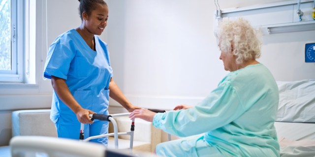 Nurse talking with patient on bed in hospital