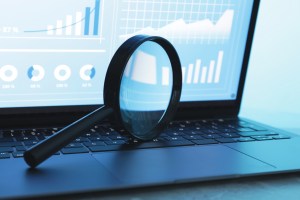 Magnifying glass on top of a laptop. New index.