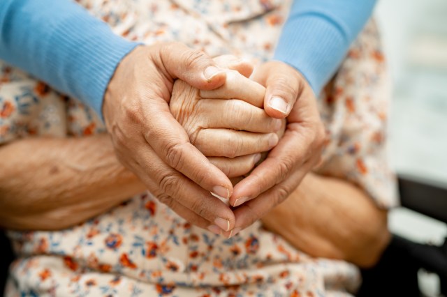 Caregiver holding hands Asian elderly woman patient with love, care, encourage and empathy at nursing hospital, healthy strong medical concept.