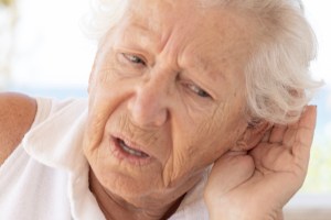 Elderly woman with hearing problem.