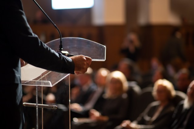 unrecognizable man having a speech in front of audience