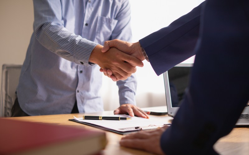 Businessmen and investors discussed joint venture within the legal counsel office and agreed to sign a contract in front of the lawyers within the legal counsel office to witness the joint investment.