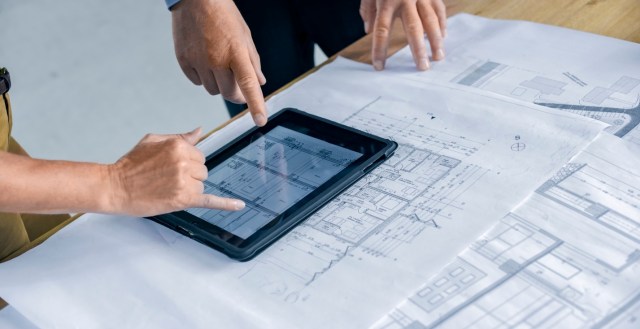 Male and female architect using digital tablet