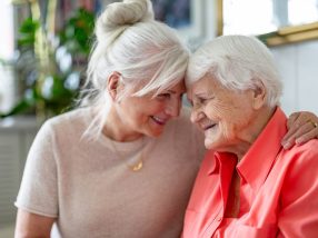 Happy senior woman with her adult daughter at home