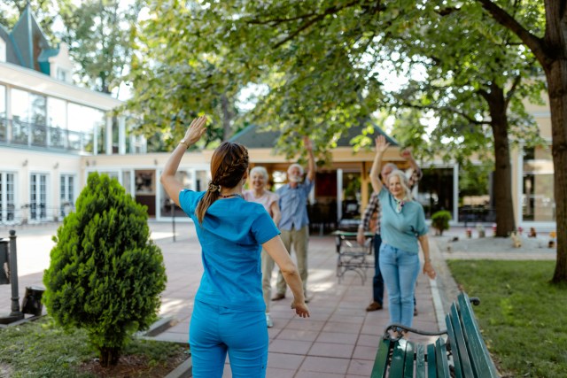 Group of Seniors With Nurse Doing Exercises at Retirement Home