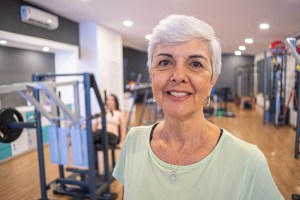 Close-up portrait of a smiling senior woman looking at the camera in a gym