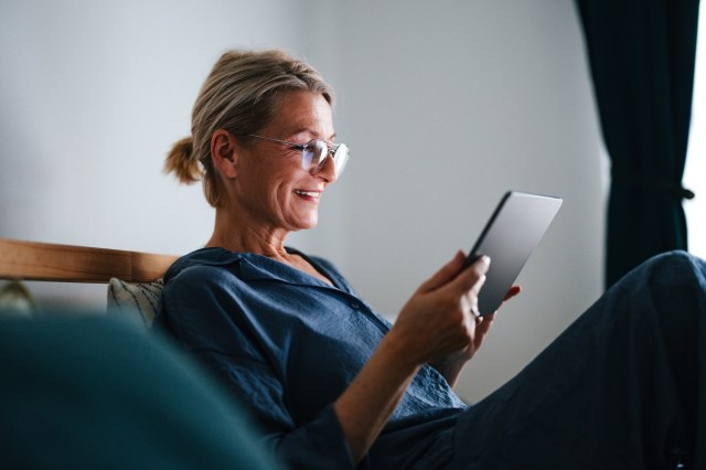 Portrait of a Senior Woman Relaxing in Her Bed and Using Digital Tablet