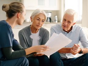Senior couple, nurse and documents in life insurance, budget planning or advice on sofa at home. Woman caregiver or medical healthcare worker consulting elderly people on paperwork in retirement plan