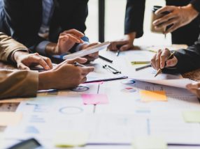 Brainstorm business meeting to discuss analysis of financial figures, graphs and growth charts of business investments to plan new business projects.