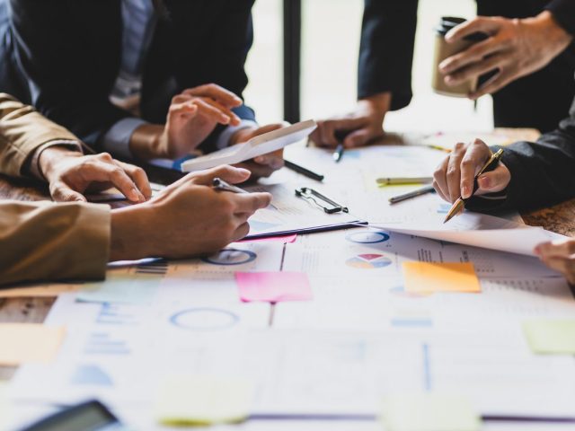 Brainstorm business meeting to discuss analysis of financial figures, graphs and growth charts of business investments to plan new business projects.