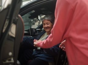 Helping a senior woman out of the car.